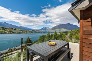 a table on a balcony with a view of the water at Remarkable Hideaway by Relaxaway Holiday Homes in Queenstown