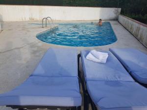 een persoon in een zwembad met twee blauwe chaises bij Casa Platja d'Aro, 3 dormitorios, 6 personas - ES-209-13 in S'Agaro