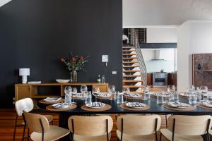 a dining room with a table with chairs and wine glasses at Warburton's Loft in Melbourne