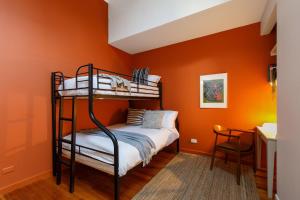 a bedroom with orange walls and a bunk bed at Warburton's Loft in Melbourne