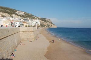 a group of people on a beach next to the ocean at Casa da Tia Matilde in Sesimbra
