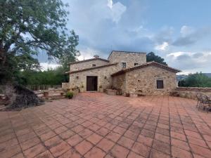 ein altes Steinhaus mit einem gemauerten Innenhof in der Unterkunft Casa Santa Cristina d'Aro, 5 dormitorios, 10 personas - ES-209-57 in Santa Cristina d'Aro