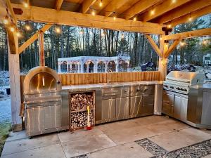 an outdoor kitchen with a stove and an oven at Le Camp Caché Shefford in Shefford