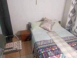 a small bedroom with a bed with a blanket on it at PagersHome Suites- RUSTIC in Kigali +26 photos