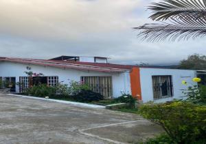 a white and orange building with a palm tree at Casa Finca Kilometro 28 Bitaco in La Cumbre