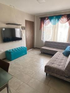 a living room with two beds and a flat screen tv at Departamento Playas Villamil vacaciones in Playas