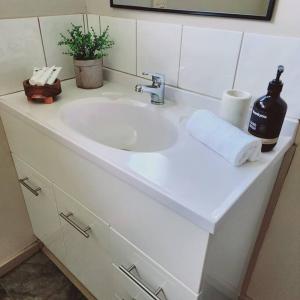 a white bathroom sink with a soap dispenser on it at Eight Acres Lakes Entrance in Lakes Entrance