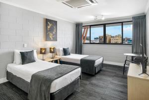 a hotel room with two beds and a window at Gilligan's Hotel & Resort Cairns in Cairns +37 photos