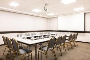 a conference room with a table and chairs and a whiteboard at Holiday Inn Express Puerto Madero, an IHG Hotel in Buenos Aires