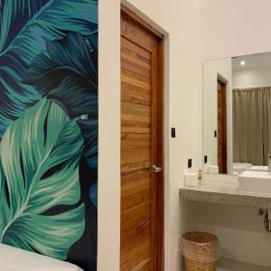 a bathroom with a door with a tropical leaf mural at Bahandi Hotel in General Luna