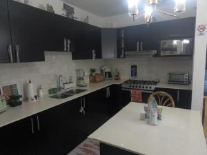 a kitchen with black cabinets and white counter tops at MADDY Free Wi-Fi, AC in ea Bedrooms, Private Community! in San Miguel