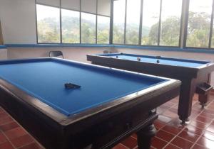 two pool tables in a room with windows at Casa Finca Kilometro 28 Bitaco in La Cumbre