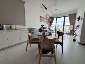 a kitchen and dining room with a table and chairs at DeLuma-Urban Suites in Jelutong