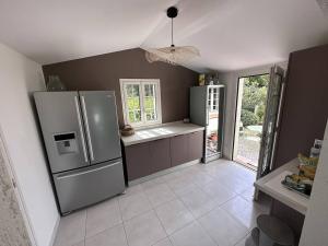 a kitchen with a stainless steel refrigerator and a window at Villa Les Issambres, 4 pièces, 6 personnes - FR-1-768-11 in Les Issambres