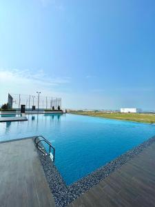 a swimming pool with blue water in a field at Melaka AmberCove Homely Seaview 2R2B in Malacca