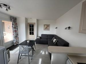 ein Wohnzimmer mit einem Sofa und einem Tisch in der Unterkunft Appartement Les Issambres, 2 pièces, 4 personnes - FR-1-768-46 in Les Issambres