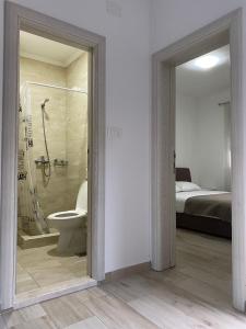 a bathroom with a shower and a toilet and a bed at P&M Ilic in Herceg-Novi