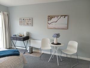 a bedroom with a bed and a table and chairs at Mount Pleasant Views in Christchurch