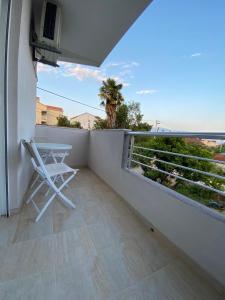 d'un balcon avec une chaise, une table et un palmier. dans l'établissement P&M Ilic, à Herceg-Novi