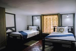 a bedroom with two beds and a window at Zamani za kale in Kabuku