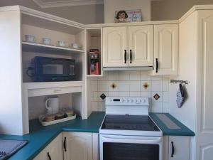 a kitchen with a white stove and a microwave at Ashburton Family Home in Ashburton