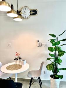 um quarto com uma mesa e um relógio e uma planta em Melaka AmberCove Homely Seaview 2R2B em Malaca