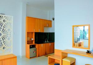 a kitchen with wooden cabinets and a mirror at Khách sạn Phố Ngọc in Nha Trang