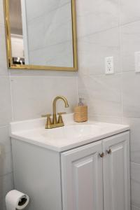 a bathroom sink with a gold faucet and a mirror at Misbau home in Brooklyn