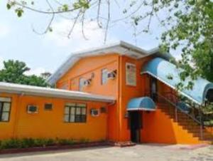 an orange building with a staircase in front of it at Abrassi hotel tayum abra in Bangued