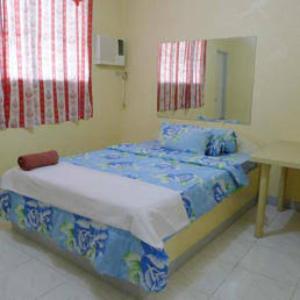 a bedroom with a bed and a desk in it at Abrassi hotel tayum abra in Bangued