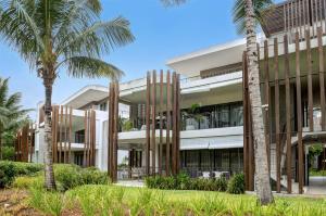 a building with palm trees in front of it at LUX APPARTMENT GOLF DE MONT CHOISY in Mont Choisy