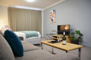 a living room with a couch and a bed at Mansfield Apartments in Mansfield