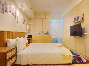 ein Schlafzimmer mit einem großen Bett und einem TV in der Unterkunft Nagasaki 長崎 at Anderson in Surabaya