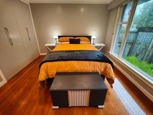 1 dormitorio con cama y ventana grande en Peaceful by the Park en Invercargill