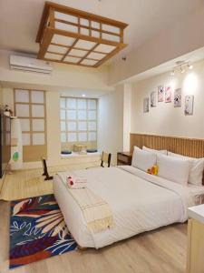 ein Schlafzimmer mit einem großen weißen Bett in einem Zimmer in der Unterkunft Nagasaki 長崎 at Anderson in Surabaya