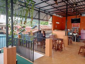 Dos personas sentadas en un bar en un balcón en OYO 93333 Rama Home Stay en Jayapura