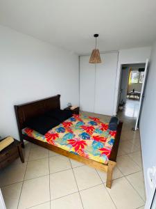 - une chambre avec un lit et une couette colorée dans l'établissement Ocean View Chambre, à Saint-Leu