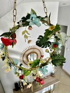 a chandelier with flowers is hanging from a chain at Ocean View Chambre in Saint-Leu