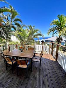 a wooden deck with a wooden table and chairs at Ocean View Chambre in Saint-Leu