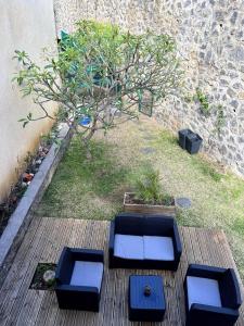 two blue seats on a wooden deck with a tree at Ocean View Chambre in Saint-Leu