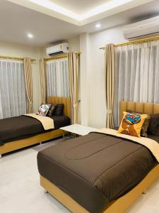 Ao Nam MaoにあるKrabi Aonang & Alpha villaのカーテン付きの客室内のベッド2台