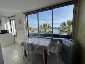 uma sala de jantar com uma mesa e vista para a água em Appartement Le Barcarès, 2 pièces, 4 personnes - FR-1-81-604 em Le Barcarès