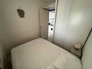 um pequeno quarto com uma cama e um espelho em Appartement Le Barcarès, 2 pièces, 4 personnes - FR-1-81-604 em Le Barcarès