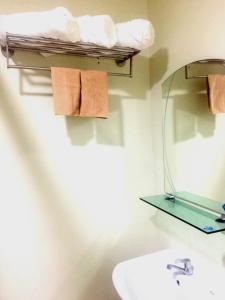 a bathroom with a sink and a shelf with towels at Brenthill Condominium in Baguio