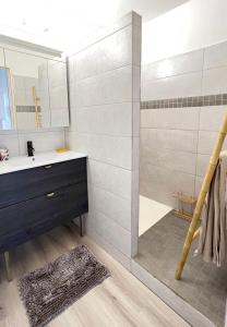 a bathroom with a sink and a shower with a mirror at L'Eden Cocoon 3 étoiles proche plage Saint Gilles les Bains in Saint-Gilles les Bains