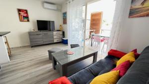 a living room with a couch and a table at L'Eden Cocoon 3 étoiles proche plage Saint Gilles les Bains in Saint-Gilles les Bains
