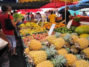 a market with many different fruits and vegetables on display at L'Eden Cocoon 3 étoiles proche plage Saint Gilles les Bains in Saint-Gilles les Bains +10 photos