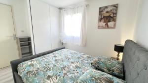 a bed in a room with a couch and a window at L'Eden Cocoon 3 étoiles proche plage Saint Gilles les Bains in Saint-Gilles les Bains