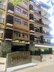 un gran edificio con un cartel delante en Brenthill Condominium en Baguio