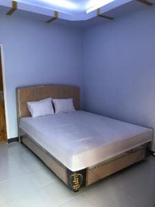 Bett in einem Zimmer mit blauer Decke in der Unterkunft de Travelodge Homestay 